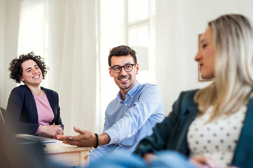 A group of people smiles during a meeting.