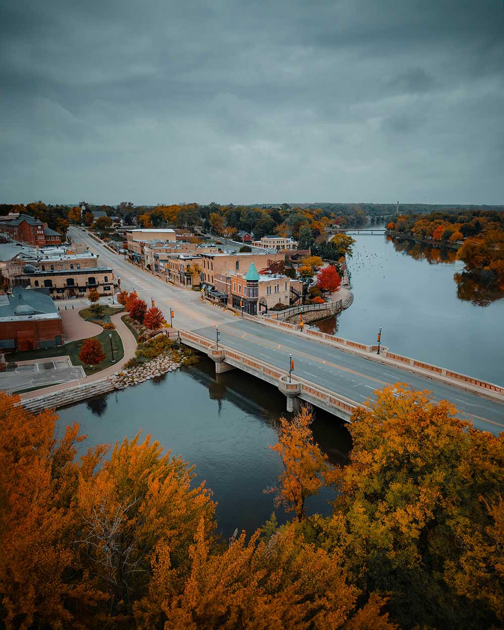 An aerial view of a town with a bridge over a river.