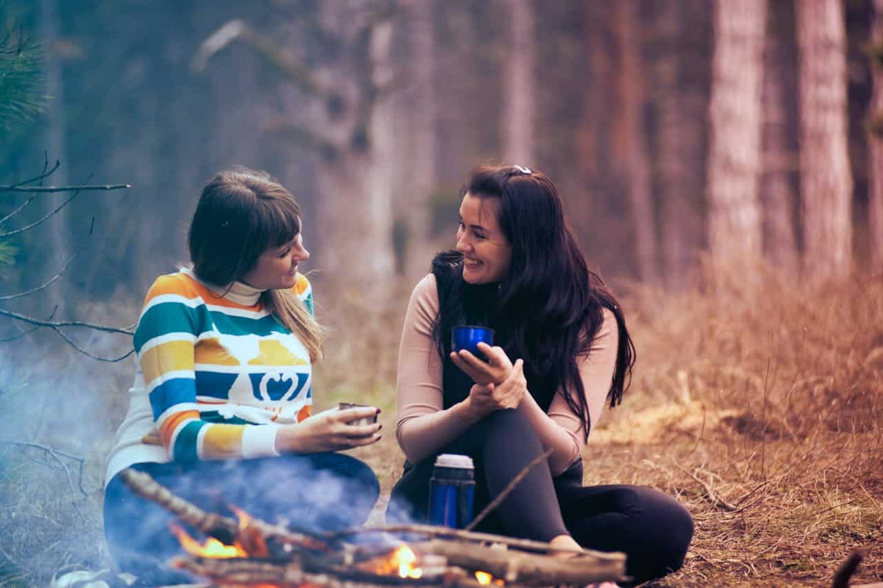 Two partners sitting together outdoors, talking calmly and building emotional connection, representing couples counseling support.