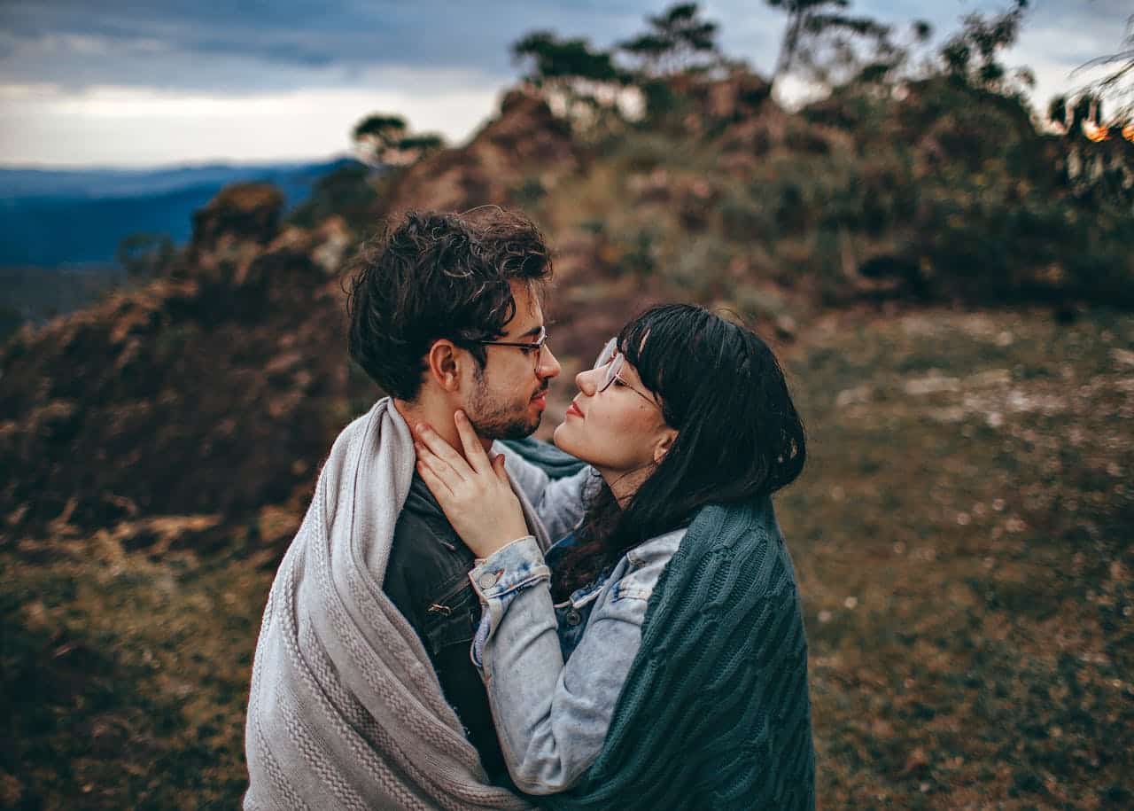 Couple facing each other in a calm outdoor setting, representing communication and emotional safety in couples therapy