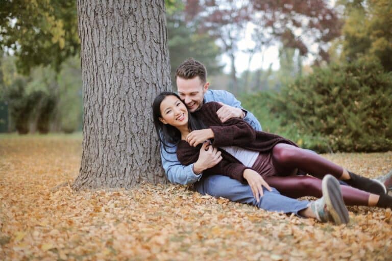 Couple sitting together outdoors, sharing a relaxed and supportive moment that reflects emotional connection in couples counseling