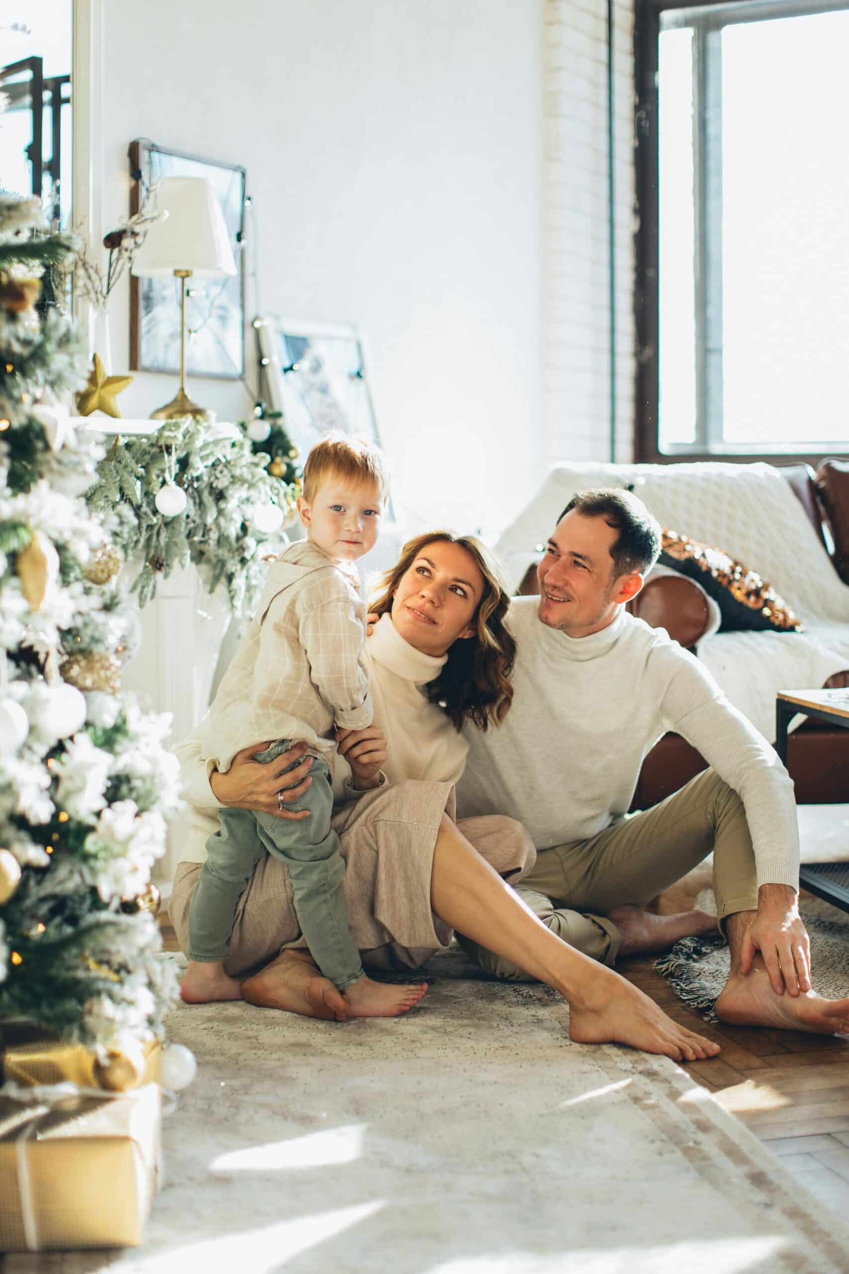 Family with young child celebrating Christmas together, festive decor and soft lights creating a joyful atmosphere