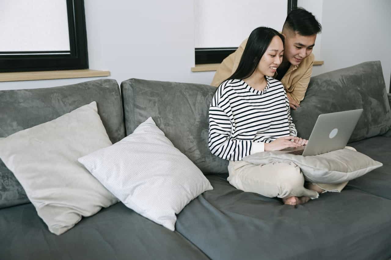 Boston couple sitting on couch reviewing relationship tips together online