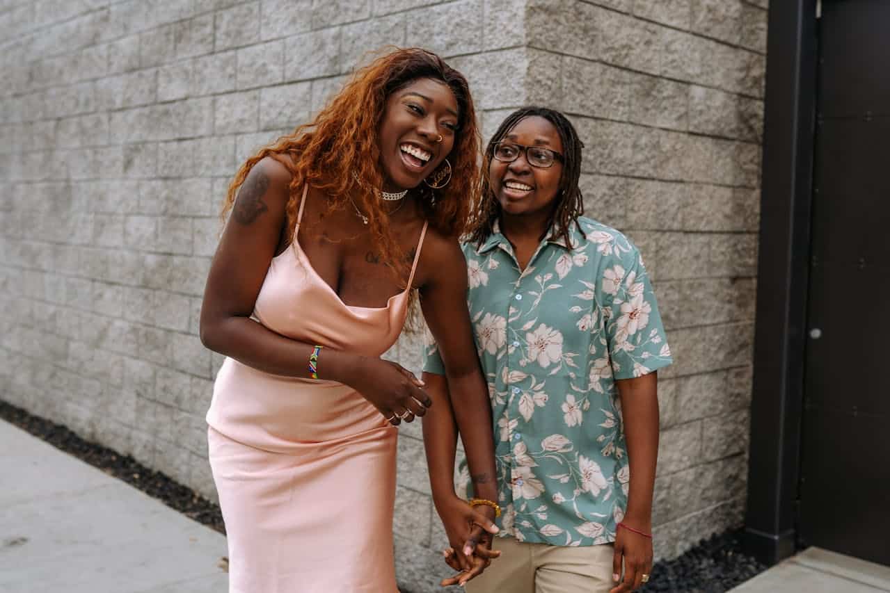 Two partners holding hands and smiling, symbolizing emotional closeness after couples therapy