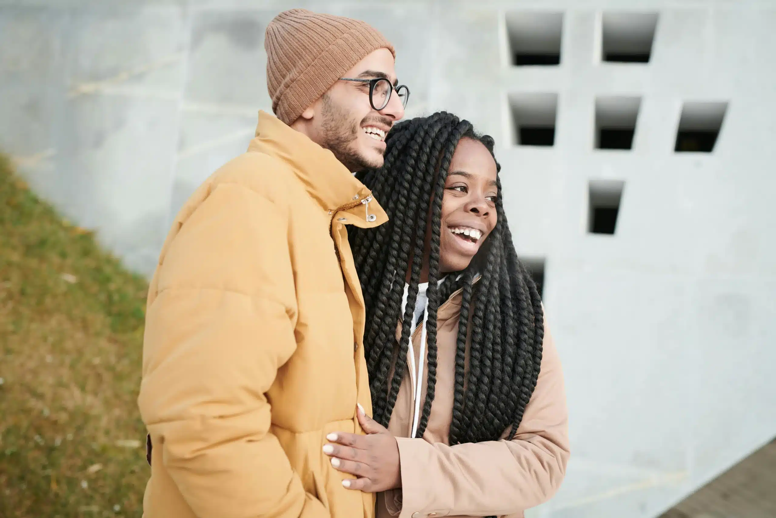  African American couple smiling and embracing warmly, expressing affection and closeness in a natural moment