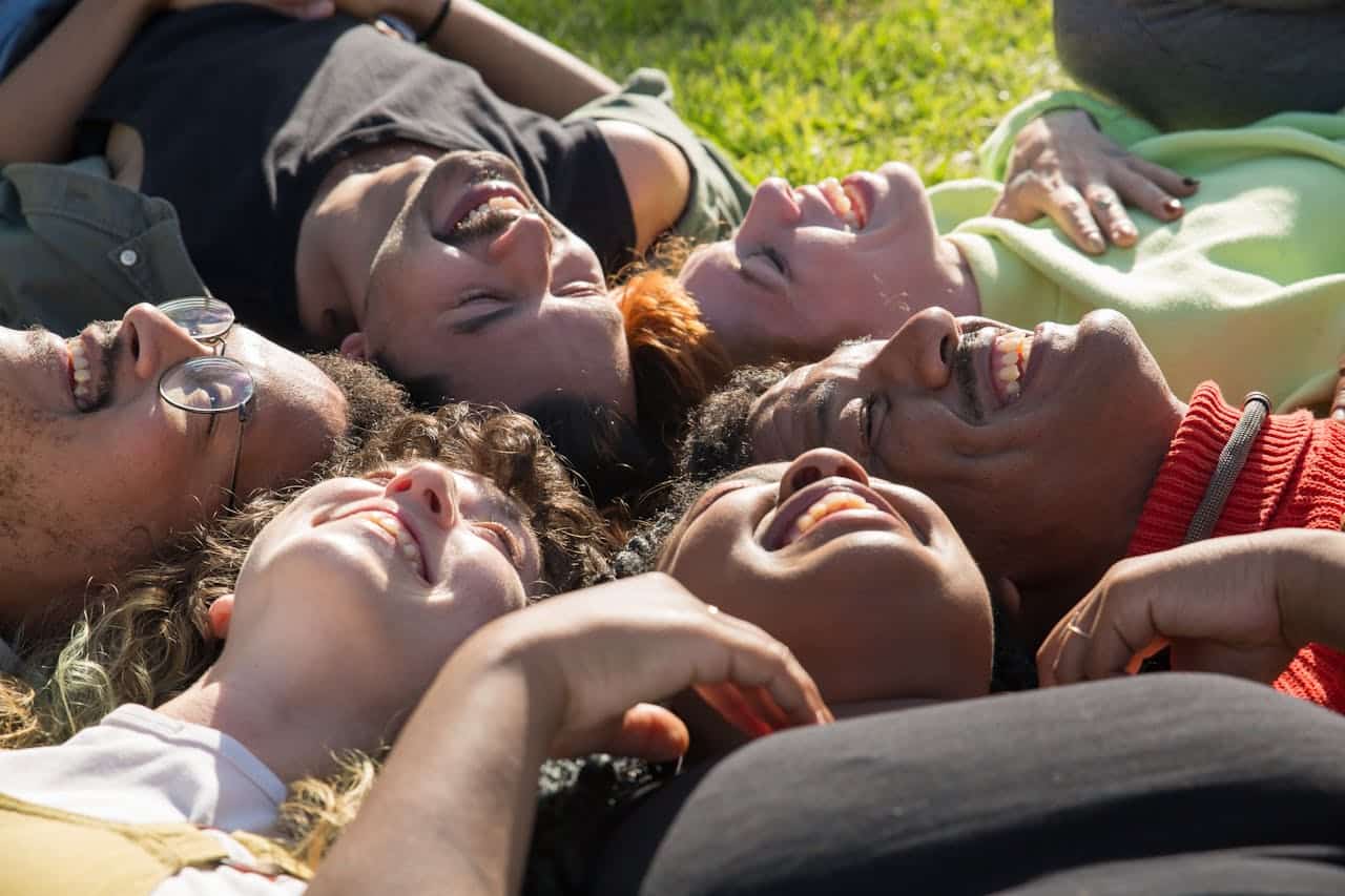 Group of adults laughing together outdoors, reflecting emotional connection in group therapy sessions