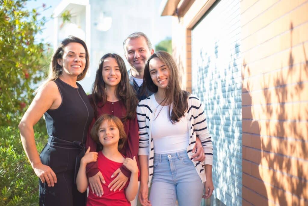 Supportive family of five smiling together, symbolizing engagement and collaboration in family therapy