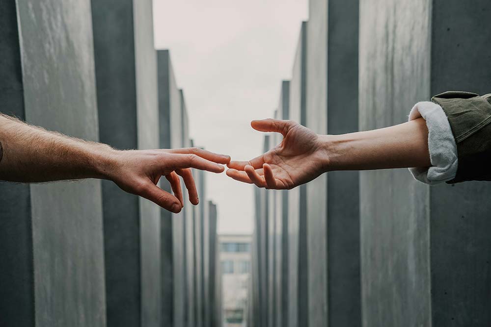 Two hands gently reaching toward each other