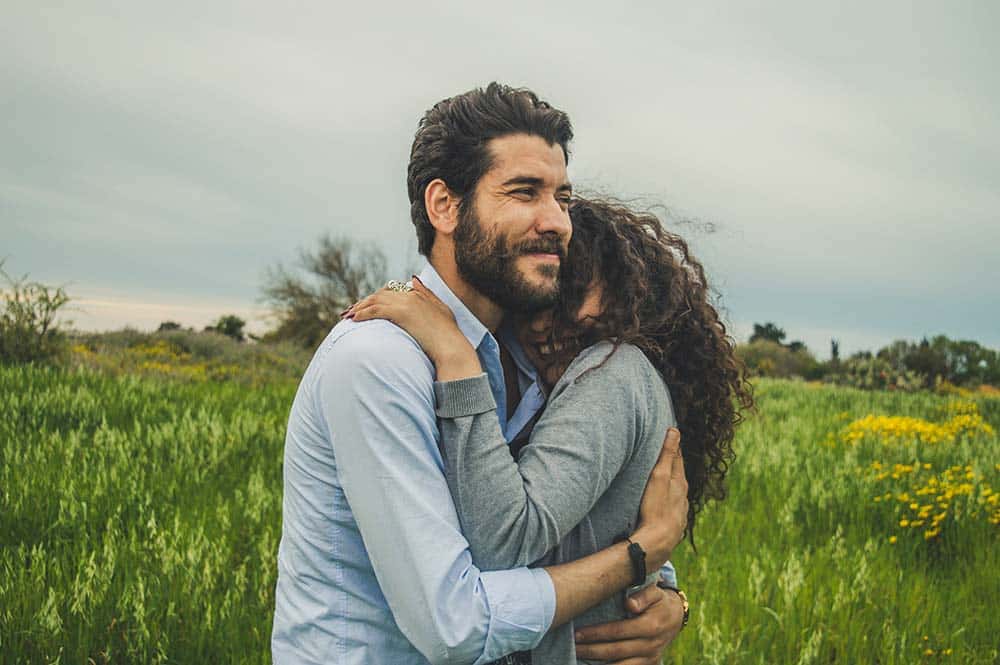a man hugging a woman in a field