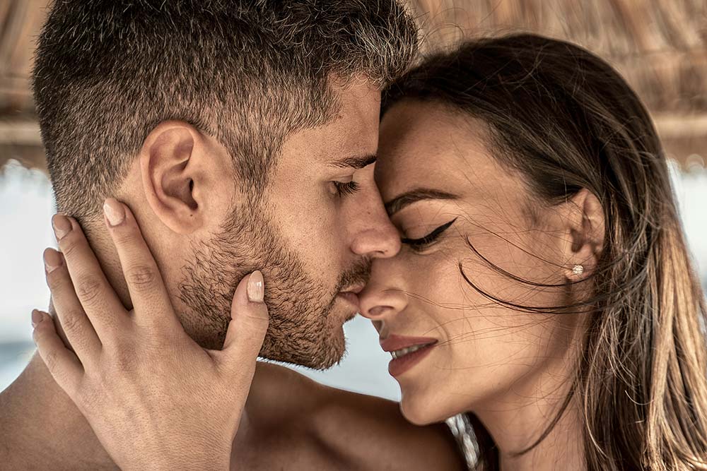 Woman gently touching a man's face.